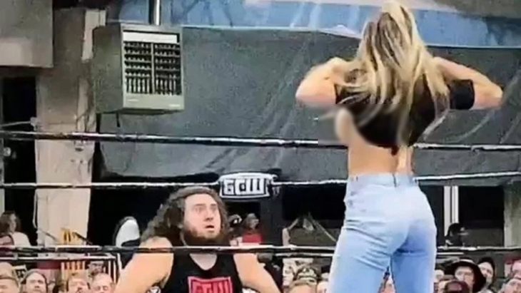 Nữ đô vật vén áo khoe ngực khiến đối thủ của chồng bị phân tâm - Ảnh 1.