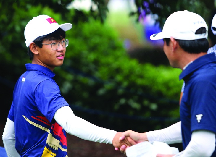 Ông Lê Văn Lân động viên con trai trước khi bước vào thi đấu. Ảnh: NAM TRẦN