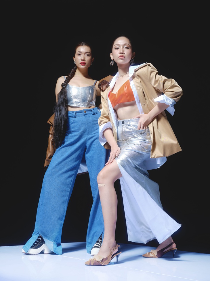 Lệ Hằng (trái) kết hợp cùng Đỗ Nhật Hà trong bộ ảnh. Á hậu Hoàn vũ Việt Nam phối crop top và quần ống rộng, còn Đỗ Nhật Hà kết hợp áo lửng như nội y màu cam và chân váy xẻ ánh kim.