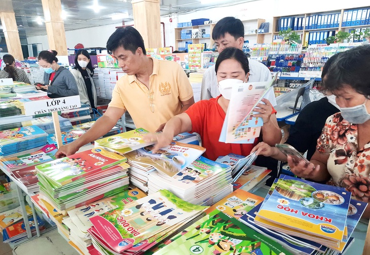 Phụ huynh và học sinh mua sách giáo khoa tại Công ty CP Sách và thiết bị trường học TP.HCM - Ảnh: NHƯ HÙNG