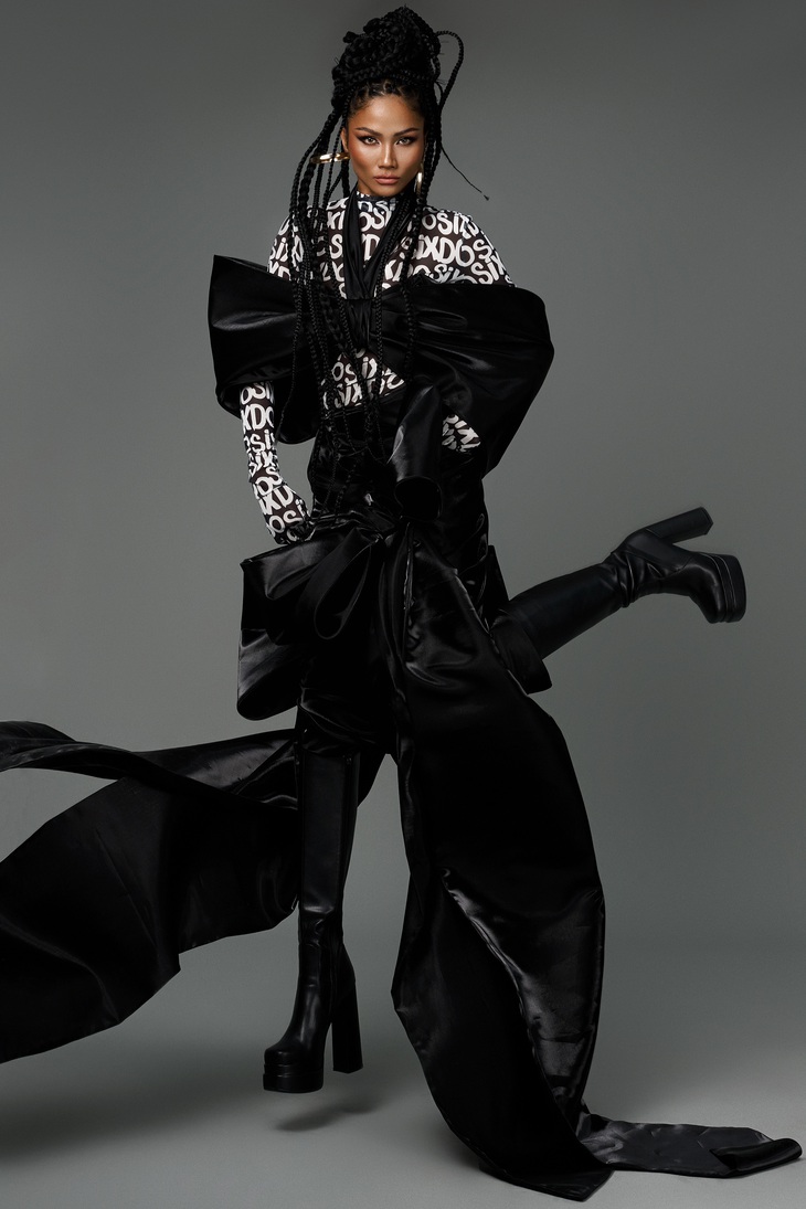 Hoa hậu H’Hen Niê diện bodysuit bên trong, mang dòng chữ SIXDO đặc trưng của thương hiệu, phối cùng trang phục được tạo phom 3D ấn tượng bên ngoài. Vẻ cá tính của trang phục được tô điểm bởi tóc tết bím nhỏ, giày boots da cao cổ.