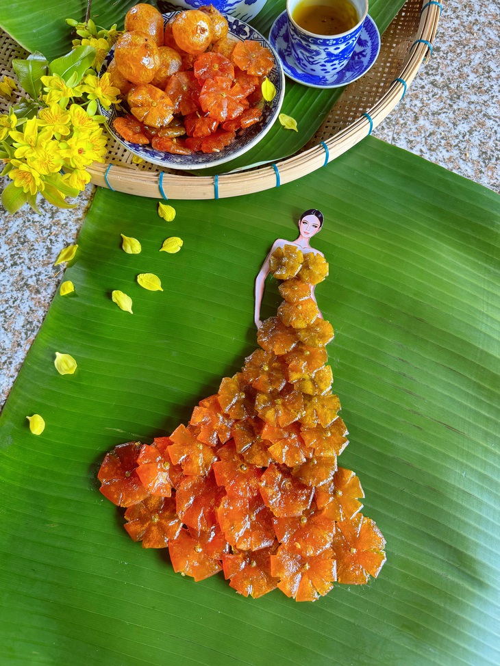 Với thiết kế mứt tắc, lại một lần nữa Nguyễn Minh Công khiến người yêu thời trang ngạc nhiên với sự tinh tế của nhà thiết kế khi cánh mứt tỉa nhiều cạnh tạo nên cánh hoa và chọn độ đậm nhạt của trái để tạo nên tổng thể chuyển màu từ xanh sang vàng như một chiếc váy dạ hội chuyển màu ombre.