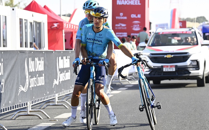 Hai tay đua xe đạp chở nhau về đích