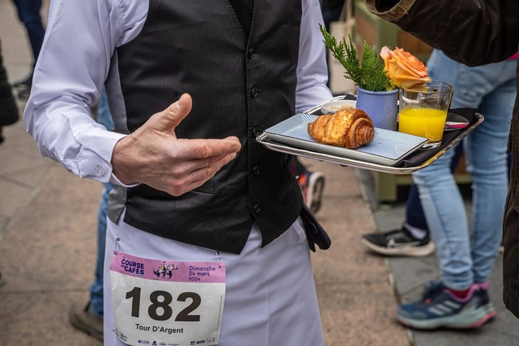 Một chiếc khay đựng bữa sáng đặc trưng kiểu Pháp, gồm một tách cà phê, một chiếc bánh croissant (bánh sừng bò) và một cốc nước. (Nguồn: Shutterstock)