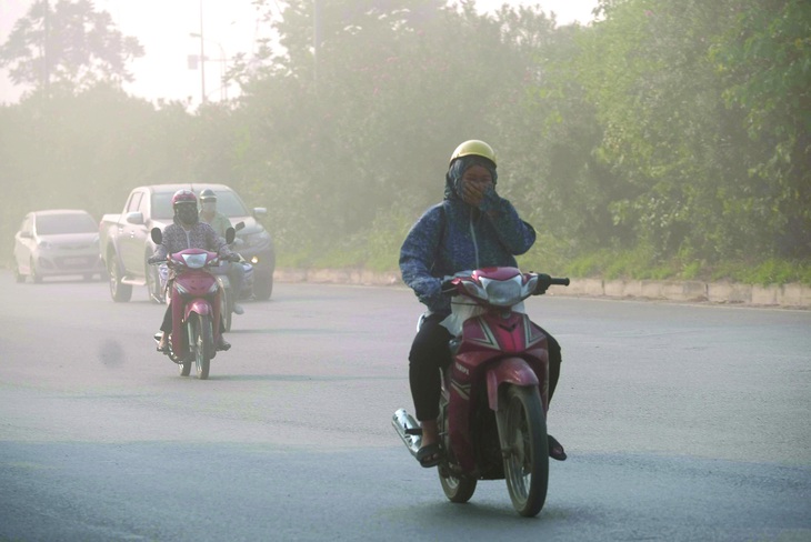 Ô nhiễm không khí khiến tầm nhìn giảm, người dân đi lại khó khăn. Ảnh: NAM TRẦN