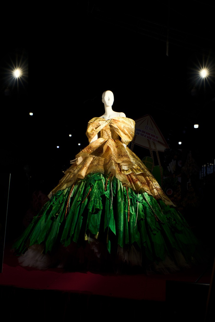 Đầm bánh xèo có tông màu chủ đạo là ánh vàng sậm đặc trưng của bánh xèo cùng tông xanh của rau được biến tấu đầy linh động, nổi bật với việc khéo léo sử dụng chất liệu in ấn 3D cùng khung dáng xòe phồng đặc trưng.