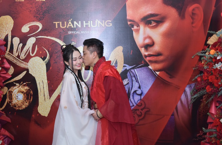 Ca sĩ Tuấn Hưng tình tứ thể hiện tình cảm với vợ trong buổi họp báo. 