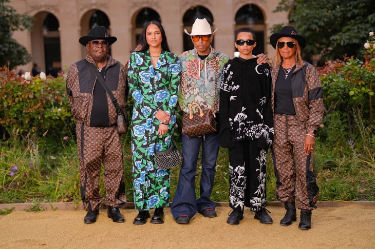 Vốn có mối quan hệ thân thiết với Nigo, Pharrell Williams đến tham dự show diễn KENZO Xuân Hè 2025 cùng gia đình của anh. Nam ca sĩ chọn diện áo hoodie hoa cùng quần jeans ống loe cá tính kết hợp mũ phớt trắng và kính râm tròng màu cam nổi bật.
