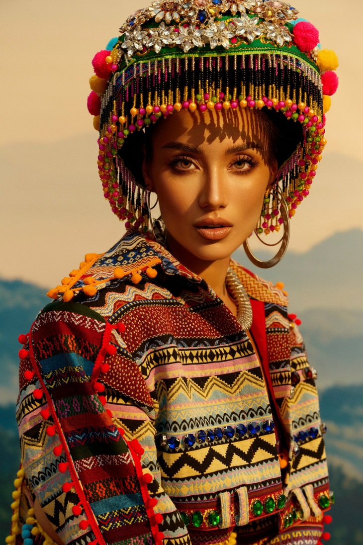 Bộ trang phục được thiết kế có phần nón được đính kết các chi tiết tua rua bắt mắt, phần tà được làm dài sang hai bên tạo cảm giác cân đối cho người mặc.&nbsp;Thêm vào đó, phần giày được làm ton-sur-ton với cả bộ trang phục giúp tạo nên tổng thể hài hòa.