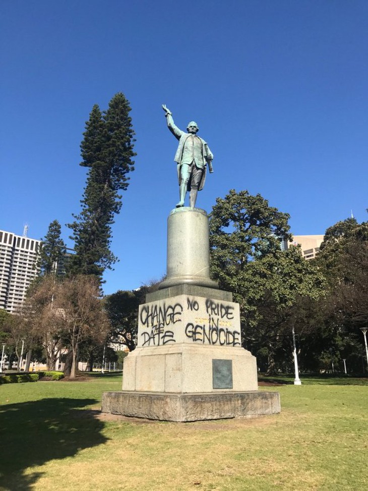 Tượng đài James Cook và dòng chữ bên phải nghĩa là “Diệt chủng thì có gì đáng tự hào”.-Ảnh: Twitter