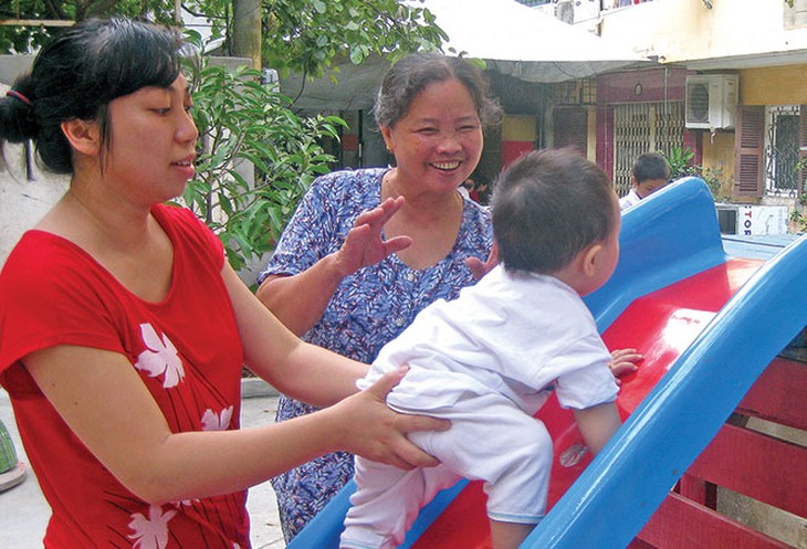 Bà Vần (giữa) vui đùa với trẻ tại sân chơi - Ảnh: Đức Triết