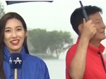 Ông chú qua đường che ô cho nữ phóng viên đang đưa tin dưới mưa