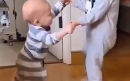 Em bé cười hạnh phúc khi được anh trai dạy tập đi