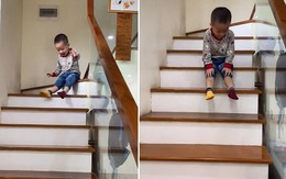 Bé trai lấy bậc thang làm cầu tuột