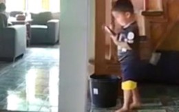 Bé trai mãi xem điện thoại ngồi gọn vào thùng nước