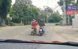 Hai người phụ nữ hồn nhiên dừng xe máy giữa đường buôn chuyện