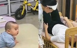 Bé trai ngơ ngác nhìn bố mẹ đùa giỡn