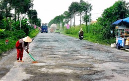Đường Xuyên Á bể nát, dân vất vả lấp ổ gà cho xe đi lại