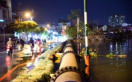 Đắp bao cát ngăn nước kênh Tẻ tràn vào đường Trần Xuân Soạn khi triều cường