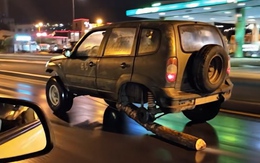 Tài xế lấy khúc gỗ thế bánh xe chạy băng băng trên đường