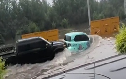 Ô tô xăng và ô tô điện dìu dắt nhau qua đường ngập